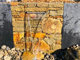 Cascade d'eau incrustée dans un mur de pierre de taille à l'ancienne à Saint Hilaire de Riez (85)