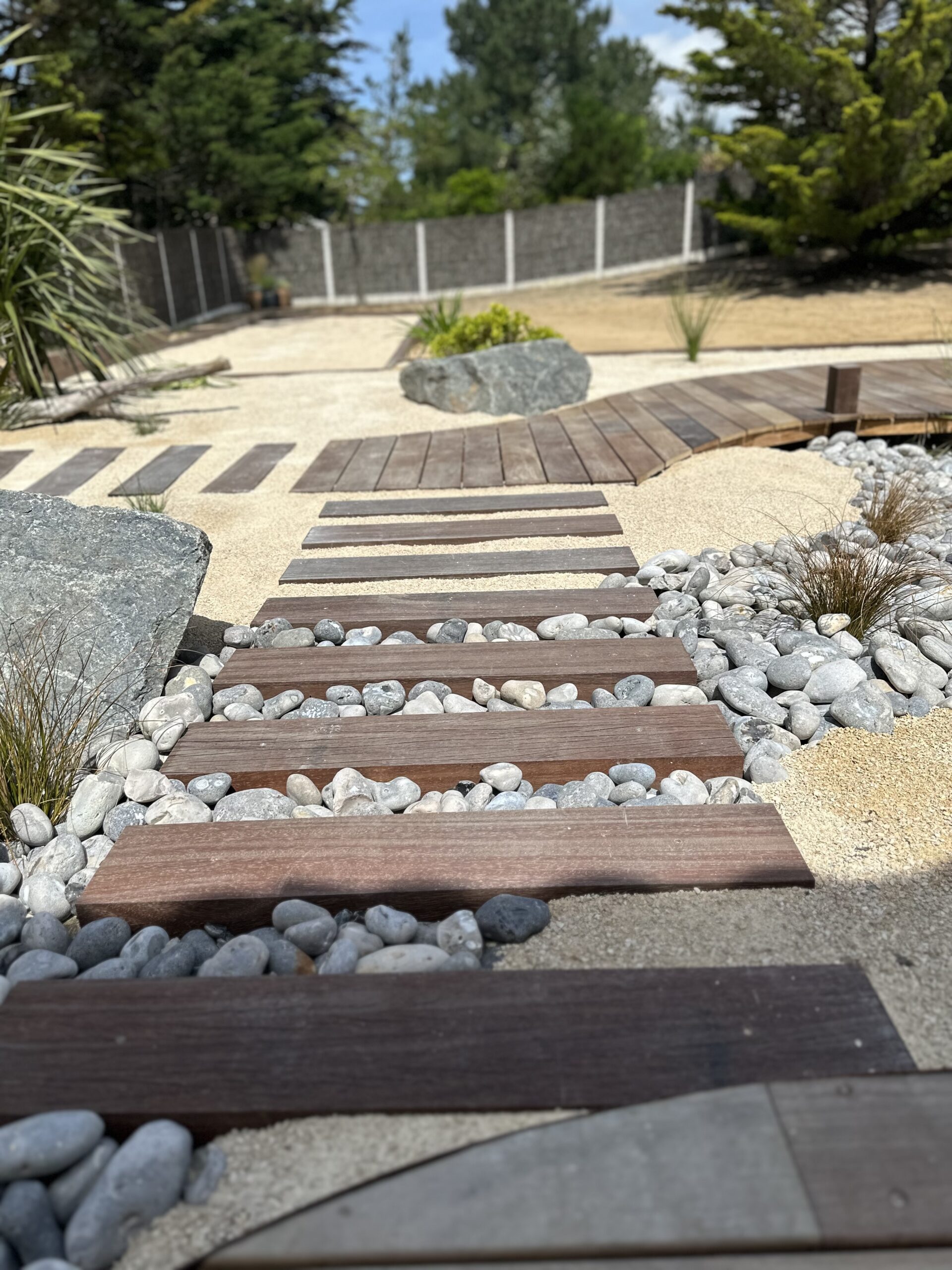 Jardin bord de mer avec chemin de traverses en bois au milieu de la rivière de galets à côté de St Gilles Croix de Vie (85) par BOTAANY Paysage et pépinière