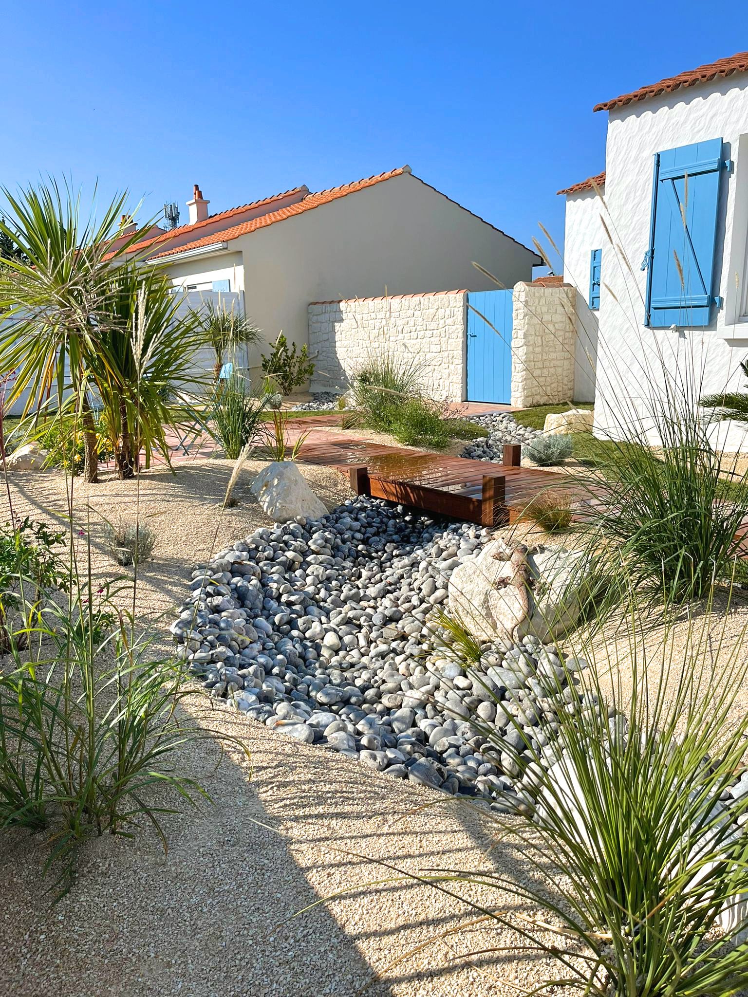 Rivière de galets, terrasse suspendue façon ponton dans un esprit bord de mer à Le Fouiller(85) Rivière de galets, terrasse suspendue façon ponton dans un esprit bord de mer à Le Fouiller(85)